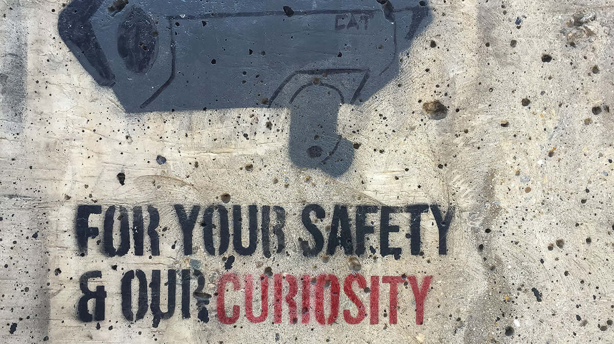 surveillance camera graffiti on a wall